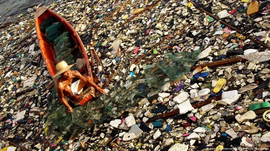 Fisherman going through waste in a river