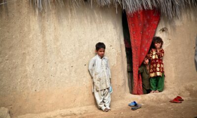 Afghan children leaning against a wall