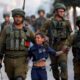 IDF soldiers arresting a Palestinian child.