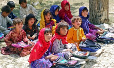 Afghani women sitting in line and holding books