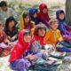 Afghani women sitting in line and holding books