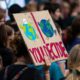 Women holding up a sign at a climate change rally.