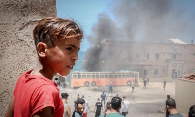 A child stands near a building in the port of Gaza that was damaged during an attack